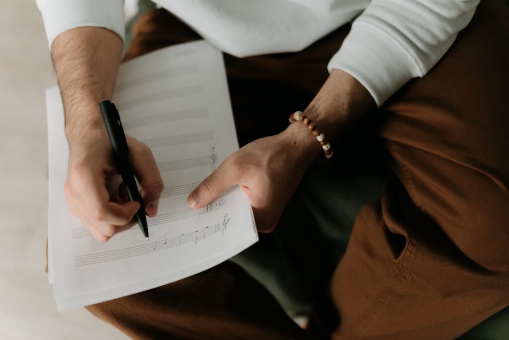 Composer writing music on staff paper.
